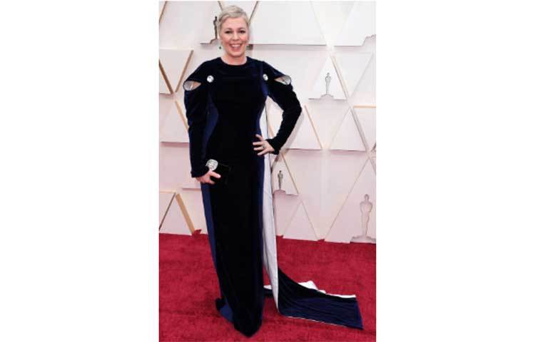 গত বছরের সেরা অভিনেত্রী অলিভিয়া কোলম্যান নীল রঙের মখমলের গাউন এবং কেপ পরেছিলেন।