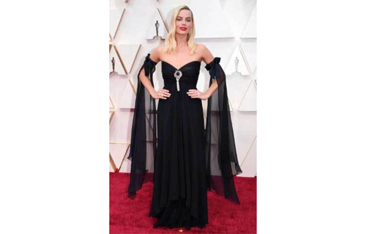 মার্গট রবি ধনুকের সাথে একটি স্নিগ্ধ এবং সাধারণ কালো পোশাক পরেছিলেন।