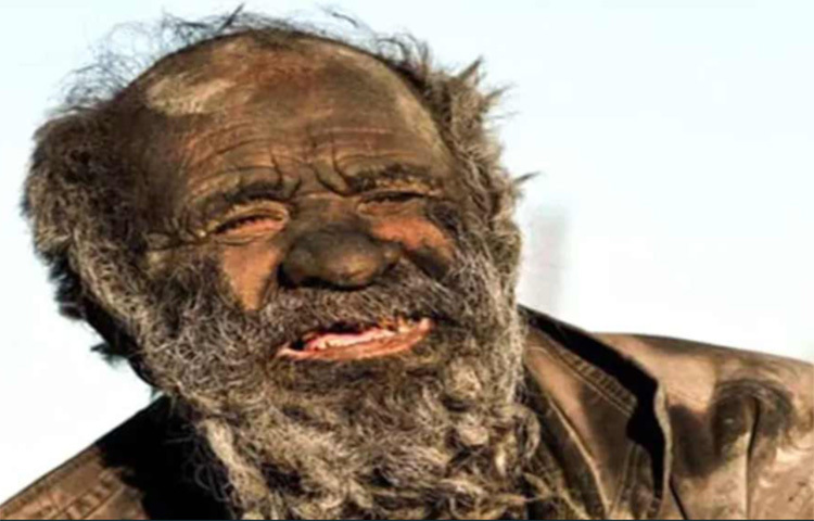 এত বছর ধরে সাবান-শ্যাম্পুর ছোঁয়া না পেয়ে হাজির চেহারা বেশ এলোমেলে হয়ে গেছে। তার ‘রূপ’ দেখে অনেকেই বলছেন, বৃদ্ধ যেন বাইবেলের পাতা থেকে উঠে আসা চরিত্রের মতো দেখতে হয়ে গিয়েছেন। ঠিক যেন রান্নাঘরের চিমনি বেয়ে নেমে আসা মোজেস। তেমনই গোঁফদাড়িতে ঢাকা গোটা মুখ। গায়-মাথা ছাইমাখা ও নোংরা। ছবি: সংগৃহীত