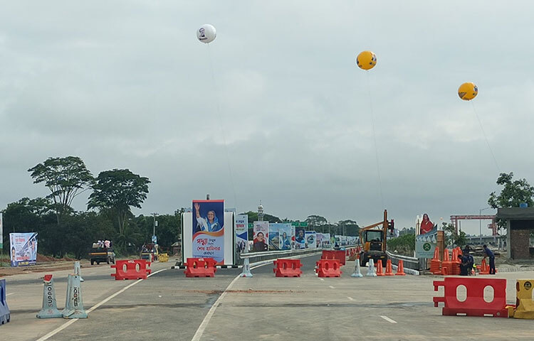 এছাড়া সেতুর নামফলক ও ম্যুরাল স্থাপনের কাজ প্রায় শেষের পর্যায়ে। অনুষ্ঠানস্থলের আশপাশে সৌন্দর্য বর্ধনের কাজও চলছে পুরোদমে। এরই মধ্যে পুরো মাওয়া এলাকায় জোরদার করা হয়েছে কয়েক স্তরের নিরাপত্তা বলয়। পুলিশ, র‌্যাব, সেনাবাহিনীর পাশাপাশি কাজ করছে বিভিন্ন আইনশৃঙ্খলা বাহিনী। ছবি: আরাফাত রায়হান সাকিব