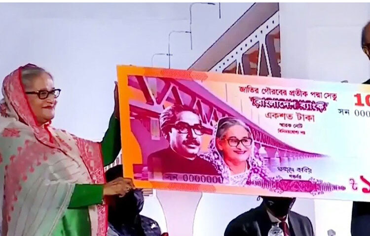 মুন্সিগঞ্জের মাওয়া প্রান্তে পদ্মা সেতুর উদ্বোধনী অনুষ্ঠানে ১০০ টাকা মূল্যমানের স্মারক নোট উন্মোচন করেন প্রধানমন্ত্রী শেখ হাসিনা। এ সময় বাংলাদেশ ব্যাংকের গর্ভনর ফজলে কবির উপস্থিত ছিলেন। ছবি: সংগৃহীত
