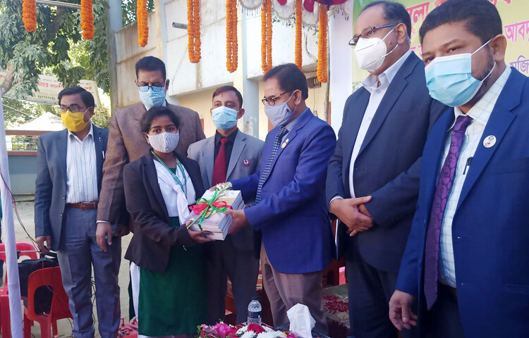 সকালে সুনামগঞ্জ সরকারি জুবলী উচ্চ বিদ্যালয়ের মাঠ প্রাঙ্গনে সামাজিক দূরত্ব বজায় রেখে শিক্ষার্থীদের হাতে বই তুলে দেন সুনামগঞ্জের জেলা প্রশাসক মোহাম্মদ আব্দুল আহাদ। ছবি: জাগো নিউজ