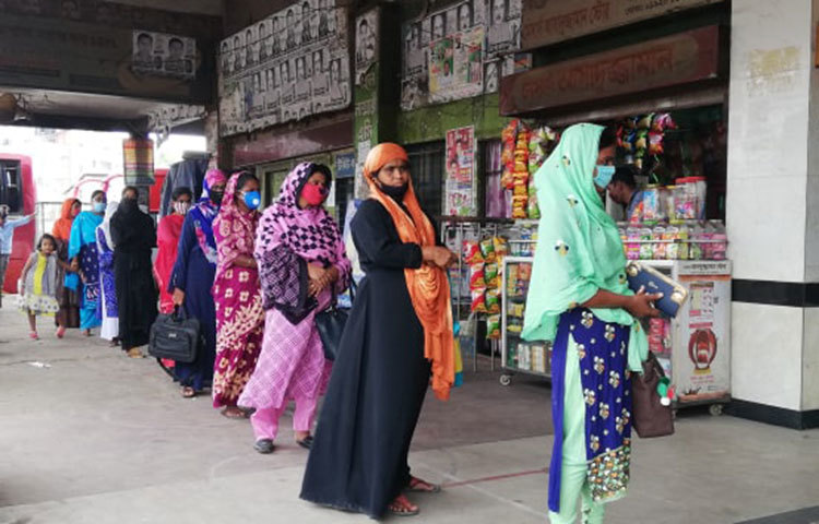 বাসের টিকেট কাটার জন্য সবাই সারিবদ্ধ হয়ে দাঁড়িয়েছেন। ছবি: মাহবুব আলম