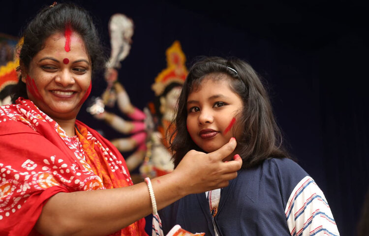 মন্দিরে পূজা দেখতে এসে আনন্দিত শিশুটি। ছবি: মাহবুব আলম