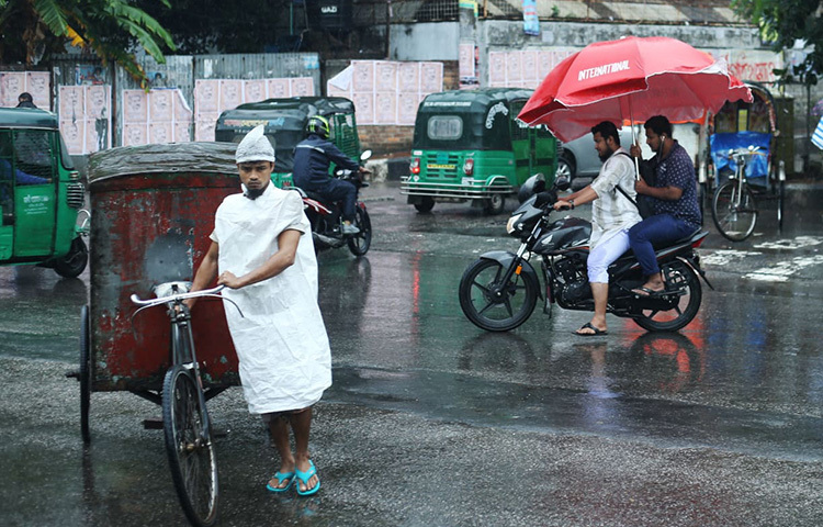 সকাল থেকে বৃষ্টি উপেক্ষা করে রাজধানবাসী নিজ নিজ কর্মক্ষেত্রে যাচ্ছেন। ছবি: মাহবুব আলম