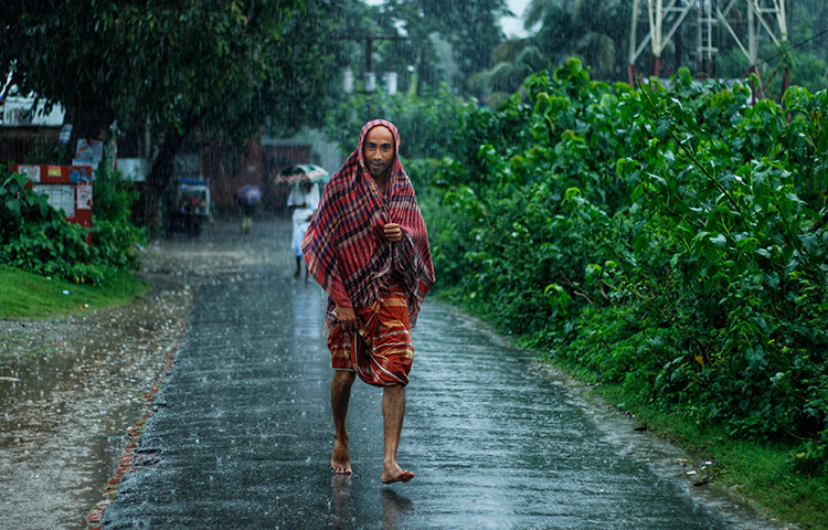 বৃষ্টি ভেজা পথ মাড়িয়ে ছুটছেন তিনি। ছবি: সাজেদুর আবেদীন শান্ত