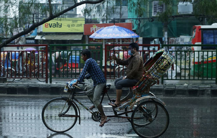 চালকের মাথায়ও ছাতা ধরেছেন এই যাত্রী। ছবি: মাহবুব আলম