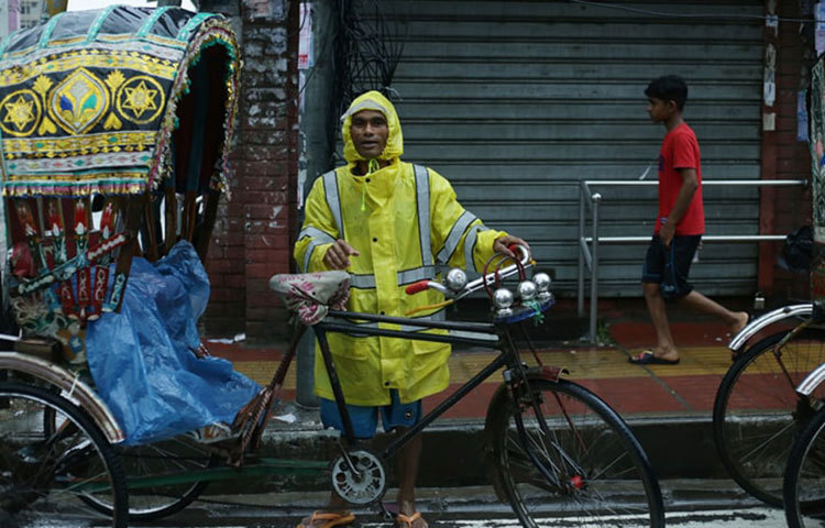 যাত্রীর অপেক্ষায় দাঁড়িয়ে আছেন এই চালক। ছবি: মাহবুব আলম