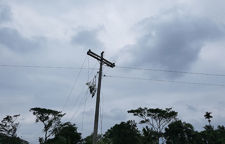 বিদ্যুতের খুঁটি উপড়ে পড়েছে, ছিড়ে গেছে লাইন। ছবি: আকরামুল ইসলাম