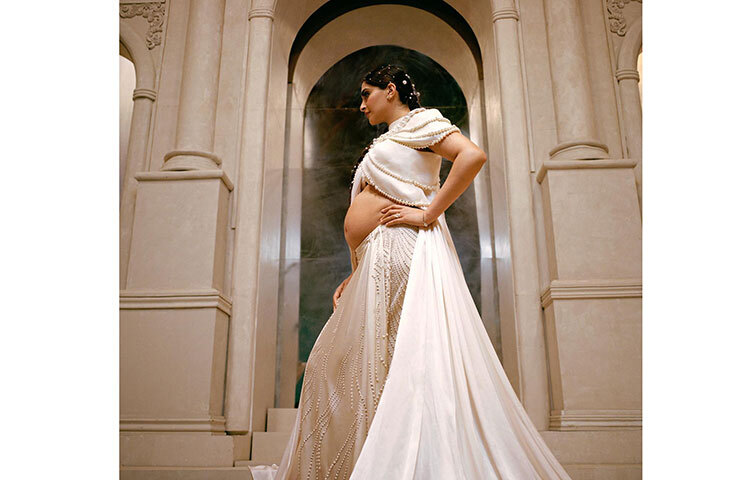 সোনম কাপুরের গায়ে জড়ানো সাদা সার্টিনের পোশাক। উপর থেকে আলগোছে শরীরে লেগে আছে সাদা ওড়না। গোটা পোশাকটিতে মুক্তোর কাজ করা। পোশাকের মধ্যে দিয়ে স্পষ্ট বেবি বাম্প। আজ নিজের জন্মদিনে এভাবেই ফটোশুট করলেন হবু মা সোনাম কাপুর। ছবি: ফেসবুক