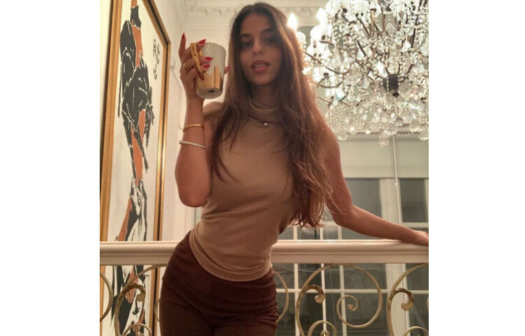 শনিবার নিজের ইনস্টাগ্রামে ৩টি ছবি পোস্ট করেছেন সুহানা খান। একটি ছবিতে বাদামী রঙের গলাবন্ধ টপ, সঙ্গে ডিপ বাদামী প্যান্ট পরে, খোলা চুলে দাঁড়িয়ে পোজ দিতে দেখা গিয়েছে শাহরুখ কন্যাকে। তার হাতে একটি কফি মাগ। সুহানার এই পোস্টে শানায়া কাপুর লিখেছেন, ‘তোমার মত কোমর পেতে পারি?’ ছবি: ইনস্টাগ্রাম