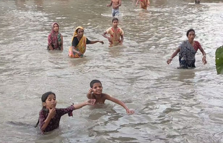 সরেজমিনে গিয়ে দেখা যায়, কোস্ট গার্ডের বোর্ডের সামনে এক প্যাকেট ত্রাণ ভিড় করেছে মানুষ। ছবি: লিপসন আহমেদ