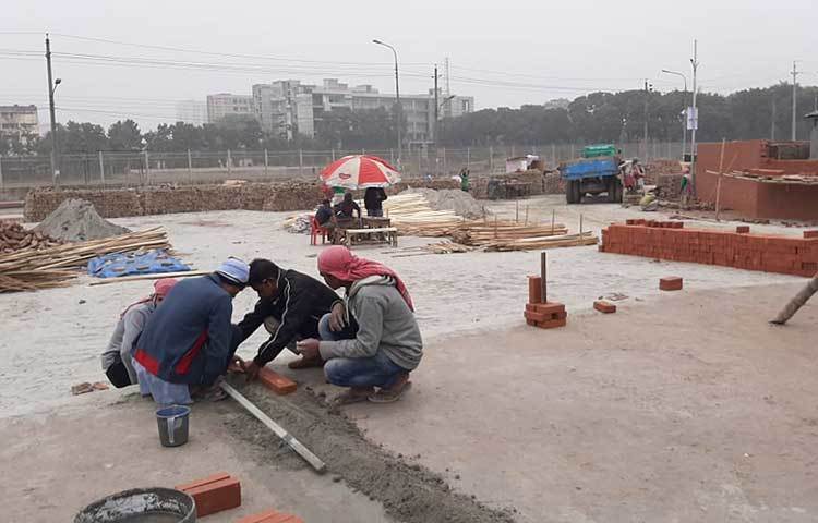 জায়গায় জায়গায় মাইক লাগানো। অনবরত বাজছে লালনগীতি। গানে বিশেষ মনোযোগী না হয়ে কেউ ইটের গাঁথুনিতে ব্যস্ত, কেউ রঙ করতে। ছবি: জাগো নিউজ