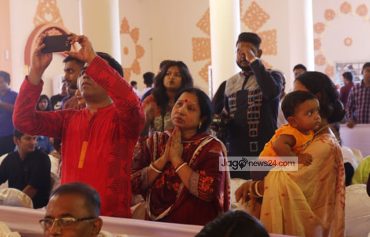 সেলফি তুলছে পূজা দেখতে আসা ভক্তরা। ছবি: মাহবুব আলম