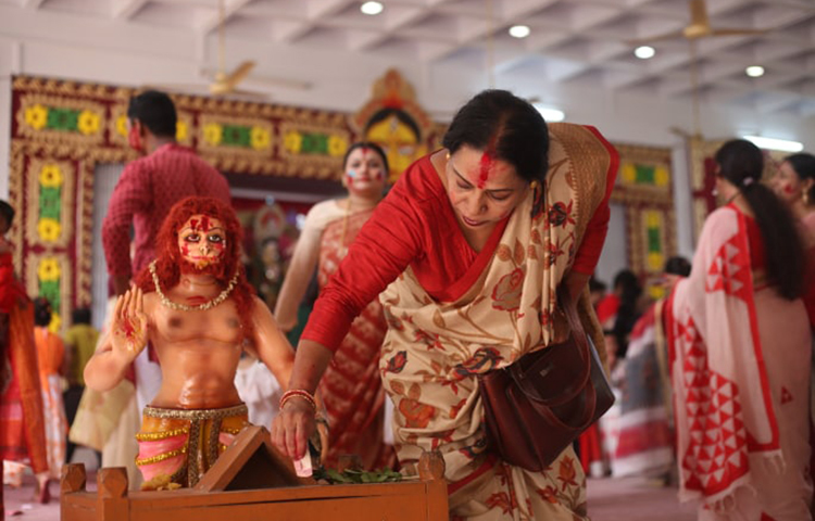 মঙ্গল কামনায় দক্ষিণা দিচ্ছেন এক নারী। ছবি: মাহবুব আলম