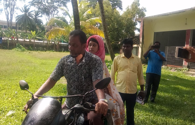 বাবার সাথে মোটর সাইকেলে বাড়ি ফিরছেন মিন্নি।