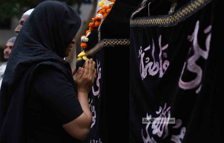 হোসনী দালানে প্রার্থনারত এক নারী। ছবি: মাহবুব আলম