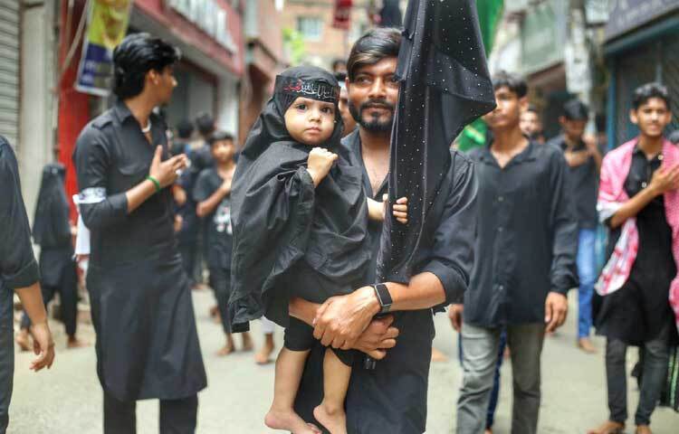 সন্তানকে কোলে নিয়ে মিছিলে অংশ নিয়েছেন বাবা। ছবি: মাহবুব আলম