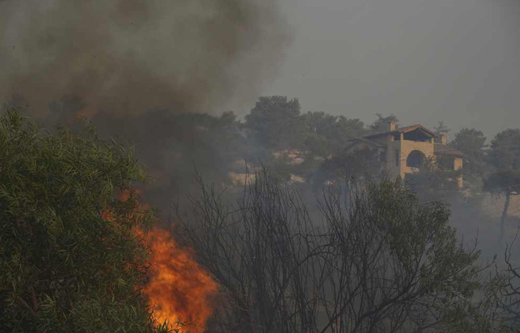 দাবানলের সময় সাইপ্রাসের সৌনি গ্রামে একটি বাড়ির কাছে আগুন জ্বলছে।