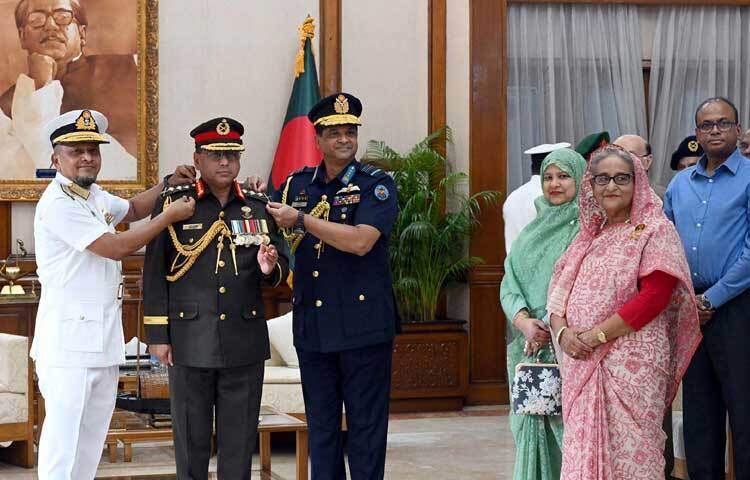 প্রধানমন্ত্রী শেখ হাসিনার উপস্থিতিতে গণভবনে নবনিযুক্ত সেনাবাহিনী প্রধান জেনারেল ওয়াকার-উজ-জামানকে র‌্যাংক ব্যাজ পরিয়ে দেন নৌবাহিনী প্রধান রিয়াল অ্যাডরিমাল মোহাম্মদ নাজমুল হাসান ও বিমান বাহিনী প্রধান এয়ার ভাইস মার্শাল হাসান মাহমুদ খাঁন। ছবি: পিআইডি