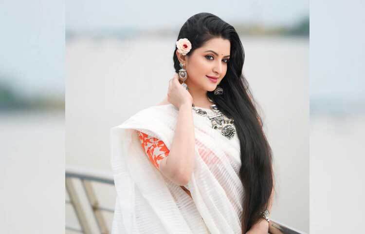 প্রিন্টের ব্লাউজের সঙ্গে সাদা শাড়ি, কানের লম্বা দুল আর গোঁজে রাখা গোলাপ ফুলে ঠিক পরীর মতোই লাগছে অভিনেত্রীকে। ছবি: ফেসবুক থেকে