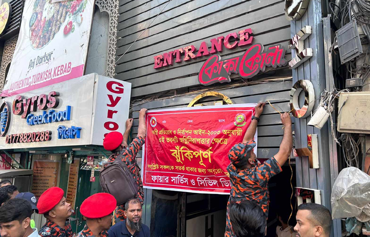 অগ্নি প্রতিরোধ ব্যবস্থা না থাকায় রাজধানীর গুলশান-২ এর একটি ছয়তলা ও আরেকটি সাততলা বাণিজ্যিক ভবন ঝুঁকিপূর্ণ ঘোষণা করে ব্যানার টানিয়ে দিয়েছেন ডিএনসিসির ভ্রাম্যমাণ আদালত। ছবি: মাহবুব আলম