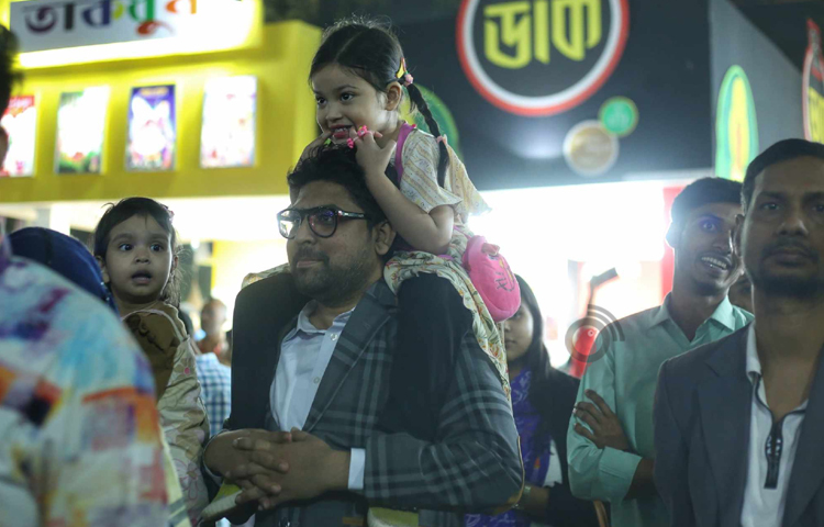 বইমেলায় বাবার কাঁধে উঠে সিসিমপুর দেখে উচ্ছ্বসিত শিশুরা। ছবি: মাহবুব আলম