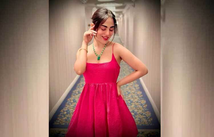 স্লিভলেস লাল ড্রেসের সঙ্গে সবুজ পাথরের নেকপিসে বেশ লাস্যময়ী লাগছে তাকে। ছবি: ফেসবুক থেকে