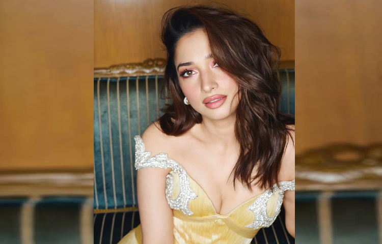 তামান্না যেটি পরেছিলেন, সেটি ছিল অফ-শোল্ডার ডিজাইনের এক মনোহর সোনালি-হলুদ গাউন। ফ্লুইড ড্রেপিং, গভীর হার্ট-শেপড নেকলাইন, কোমরে নিখুঁত ফিটিং আর এক পাশ থেকে উঠে যাওয়া থাই-হাই স্লিট, সব মিলিয়ে গাউনটির প্রতিটি খুঁটিনাটি ডিজাইন যেন ফ্যাশন ও সৌন্দর্যের নিখুঁত সংজ্ঞা হয়ে উঠেছে।