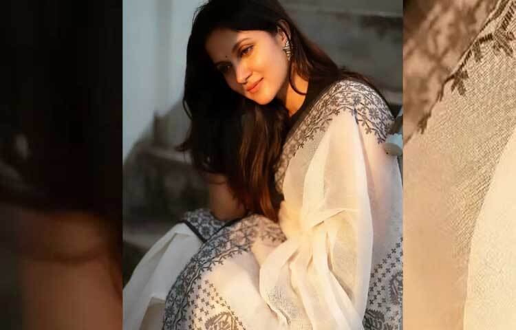 স্লিভলেস ব্লাউজের সঙ্গে সাদা শাড়ি আর হালকা সাজে বেশ স্নিগ্ধ লাগছে তাকে। ছবি: ফেসবুক থেকে