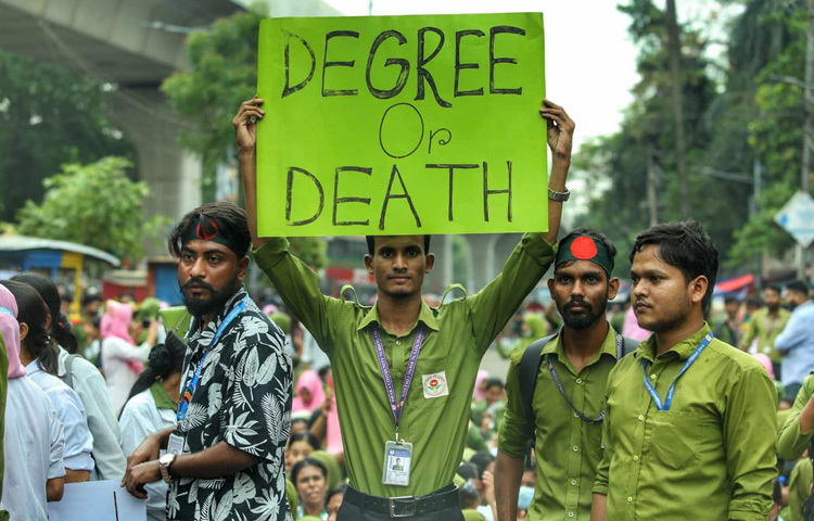 প্ল্যাকার্ড হাতে বিক্ষোভ কর্মসূচিতে অংশ নিয়েছেন শিক্ষার্থীরা।