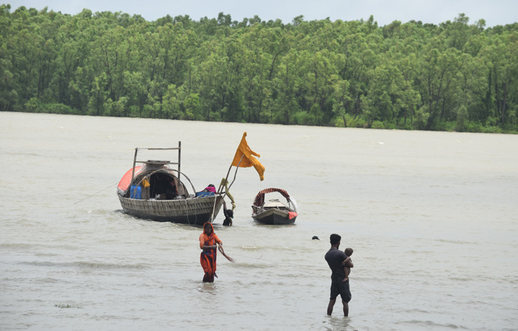 ঐ নারীর খানিকটা দূরে একজন পুরুষ ছিলেন। লুঙ্গি কাছা দেওয়া লোকটির কোলে আরেকটি শিশু। বয়স আনুমানিক ১ বছর। কেবল দাঁড়াতে শিখেছে। বোঝা যাচ্ছিল, তারা বাবা-সন্তান। শিশুটিকে নিয়ে আস্তে আস্তে তিনি পানিতে থাকা নারীর কাছে এলেন।