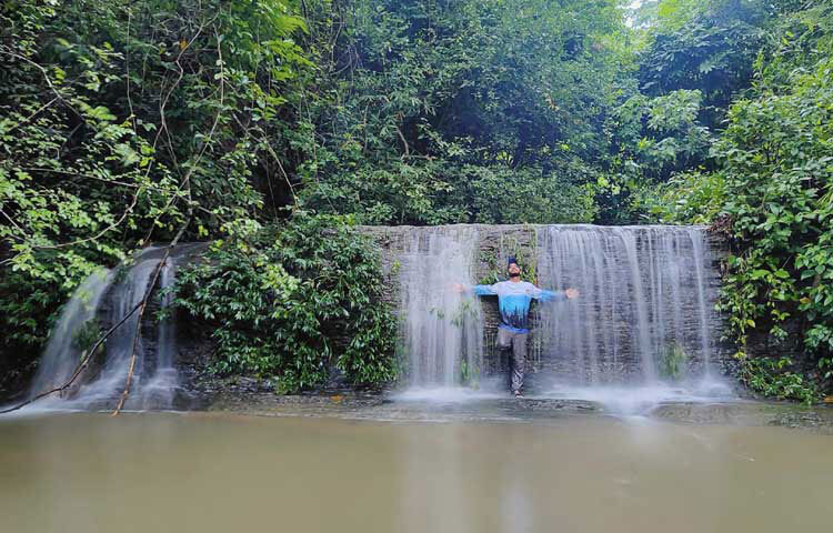 মূল রাস্তা থেকে পাহাড়ি পথ বেয়ে কিছু দূর এগিয়ে গেলেই শোঁ শোঁ শব্দ কানে বাজবে। খানিকটা হেঁটে সামনে গেলে পাহাড়ের আড়াল থেকে বেরিয়ে আসবে শব্দের উৎস। দেখবেন, বিশাল পাথুরে পাহাড়ের গাঁ বেয়ে তীব্র বেগে নেমে আসছে ঝরনাধারা। ছবি: এম মাঈন উদ্দিন