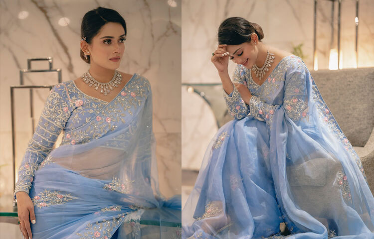 ছবির মার্বেল ব্যাকড্রপ আর নরম আলো শাড়ির রঙ ও কাপড়ের সৌন্দর্যকে আরও ফুটিয়ে তুলেছে। পুরো কম্পোজিশনটিই মনে করিয়ে দেয় ফ্যাশন শুধু পোশাক নয়; আলো, পরিবেশ, ভঙ্গি সব মিলিয়ে গড়ে ওঠে সম্পূর্ণ প্রকাশ।