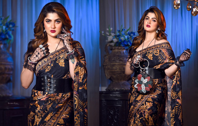 ফো লেদারের করসেট আর নেটের গ্লাভসের সঙ্গে দেশি শাড়ির ফিউশন লুকে দারুণ লাগছে তাকে।