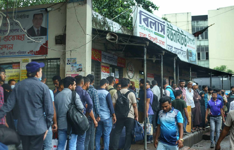 এক তরুণ দাঁড়িয়ে আছেন লাইনের একদম শেষ মাথায়। পিঠে ব্যাগ, হাতে মোবাইল আর চোখে বাড়ি ফেরার আনন্দ।