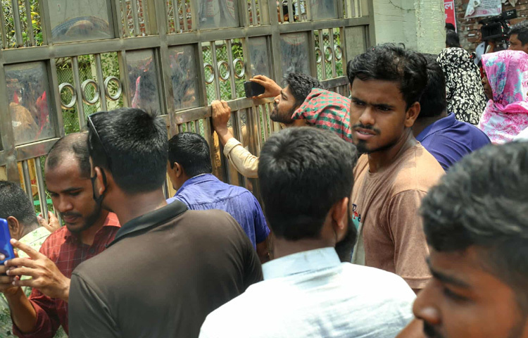 কেউ স্কুলে ঢুকতে পারছেন না; না মিডিয়া কর্মী, না অভিভাবক, না শিক্ষার্থী। গেইটের বাইরে দাঁড়িয়ে উৎসুক জনতা, কেউবা হাতে ক্যামেরা, কেউবা মোবাইলে দৃশ্য ধারণে ব্যস্ত। স্কুলের গেইট পেরিয়ে কেউ কি বের হবেন? ভেতরে কী ঘটছে? এমন প্রশ্ন ঘুরপাক খাচ্ছে সবার মুখে মুখে। আর সেই কৌতূহল থেকেই কেউ দেয়ালের ফাঁক দিয়ে, কেউ ছাদ থেকে ক্যামেরা তাক করে সংগ্রহ করছেন ছবি-ভিডিও।
