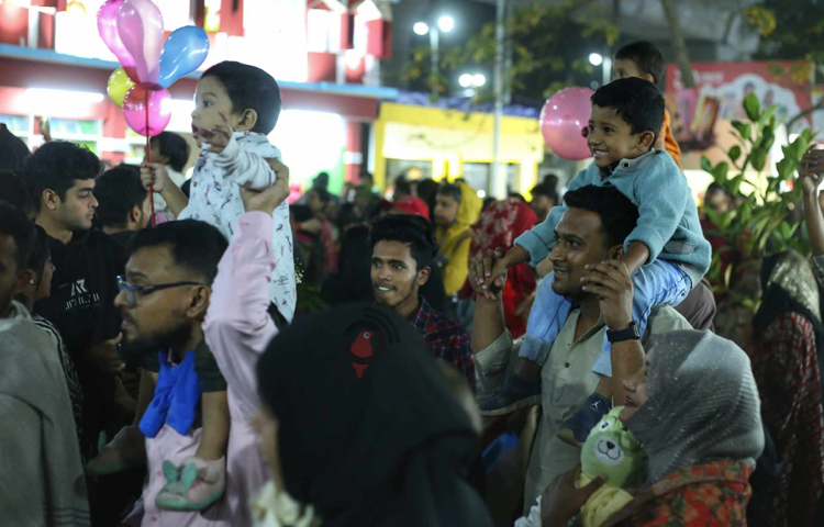বাবার কাঁধে চড়ে বইমেলায় ঘুরতে পেরে আনন্দিত শিশুরা। ছবি: মাহবুব আলম