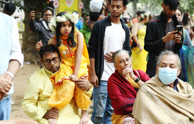 বাবার কাঁধে চড়ে বসন্ত উৎসব উপভোগ করছে মেয়ে। ছবি: মাহবুব আলম