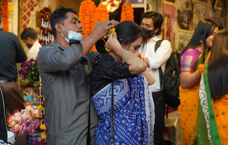 খোপায় ফুল পরিয়ে দিতে সাহায্য করছে প্রেমিকা। ছবি: মাহবুব আলম