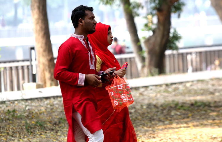 লাল রংয়ের মেচিং পোশাক পরে রমনা পার্কে ঘুরে বেড়াচ্ছেন যুগল। ছবি: বিপ্লব দীক্ষিত