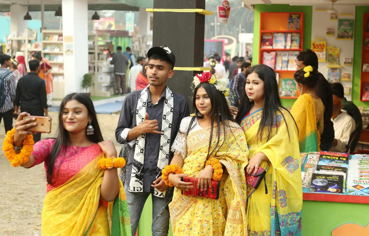 অনেকের মাথায় ফুলের টায়া, কেউ আবার চুলে আর কানে ফুল গুঁজে প্রিয়জনের সঙ্গে মেলায় এসেছেন। ছবি: মাহবুব আলম