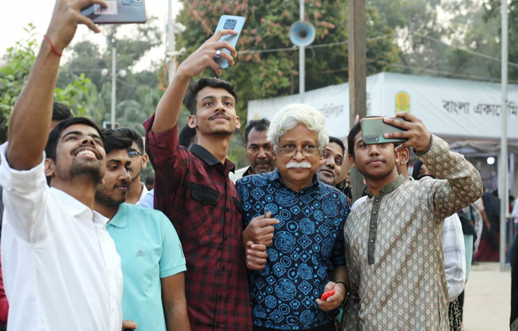 বইমেলায় জাফর ইকবালের সঙ্গে সেলফি তুলতে ব্যস্ত কিশোর-তরুণরা। ছবি: মাহবুব আলম