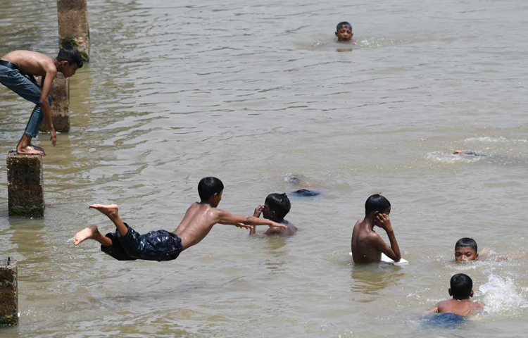 তপ্ত দুপুরে রাজধানীর হাতিরঝিলে ঝাঁপিয়ে পড়ছে শিশুরা। ছবি: বিপ্লব দীক্ষিত