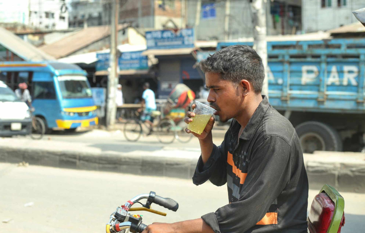 শরবত খেয়ে বেশ খুশি রিশকাচালক ও শ্রমজীবীরা। ছবি: মাহবুব আলম