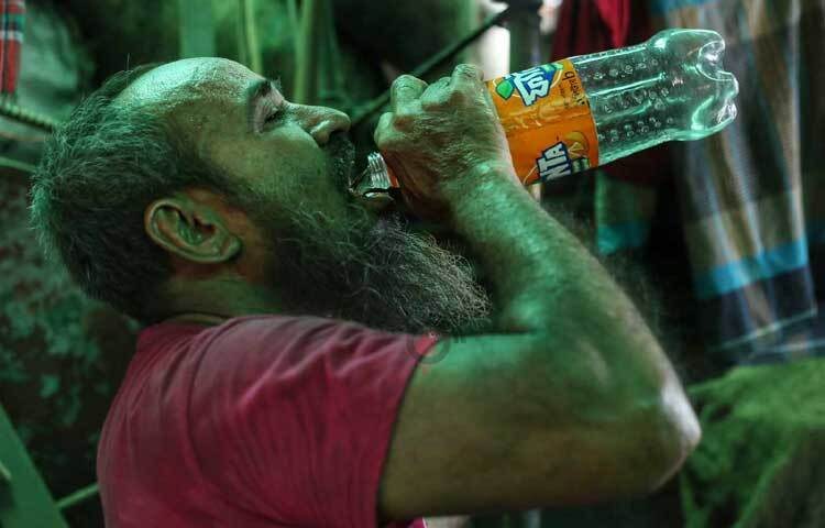 গরমে তৃষ্ণা মেটাতে কিছুক্ষণ পর পর পানি পান করছেন তারা। ছবি: মাহবুব আলম