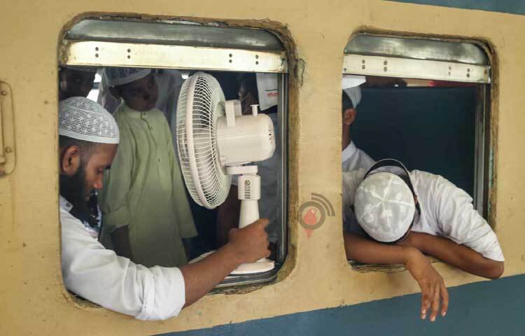 গরম থেকে বাঁচতে ট্রেনে চার্জার ফ্যান নিয়ে উঠেছেন যাত্রী। ছবি: মাহবুব আলম