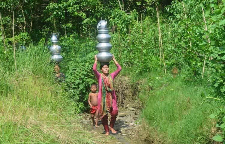 মাথায় করে হাড়িভর্তি পানি বয়ে নিচ্ছেন নারীরা। ছবি: এম মাঈন উদ্দিন