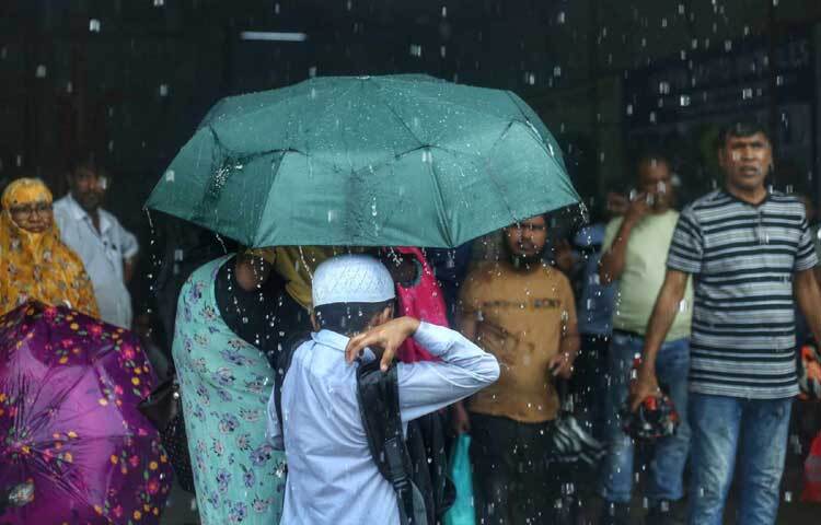 ছাতা মাথায় ছুটছেন সবাই। ছবি: মাহবুব আলম