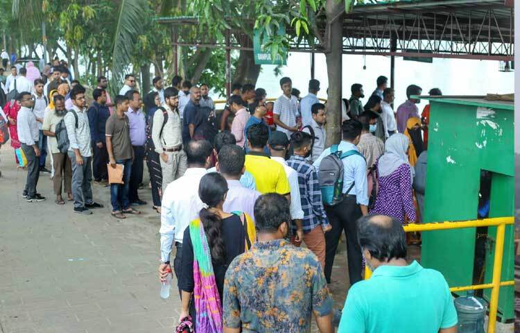 গণপরিবহনের জন্য দীর্ঘ লাইনে অপেক্ষা করছেন তারা। ছবি: মাহবুব আলম